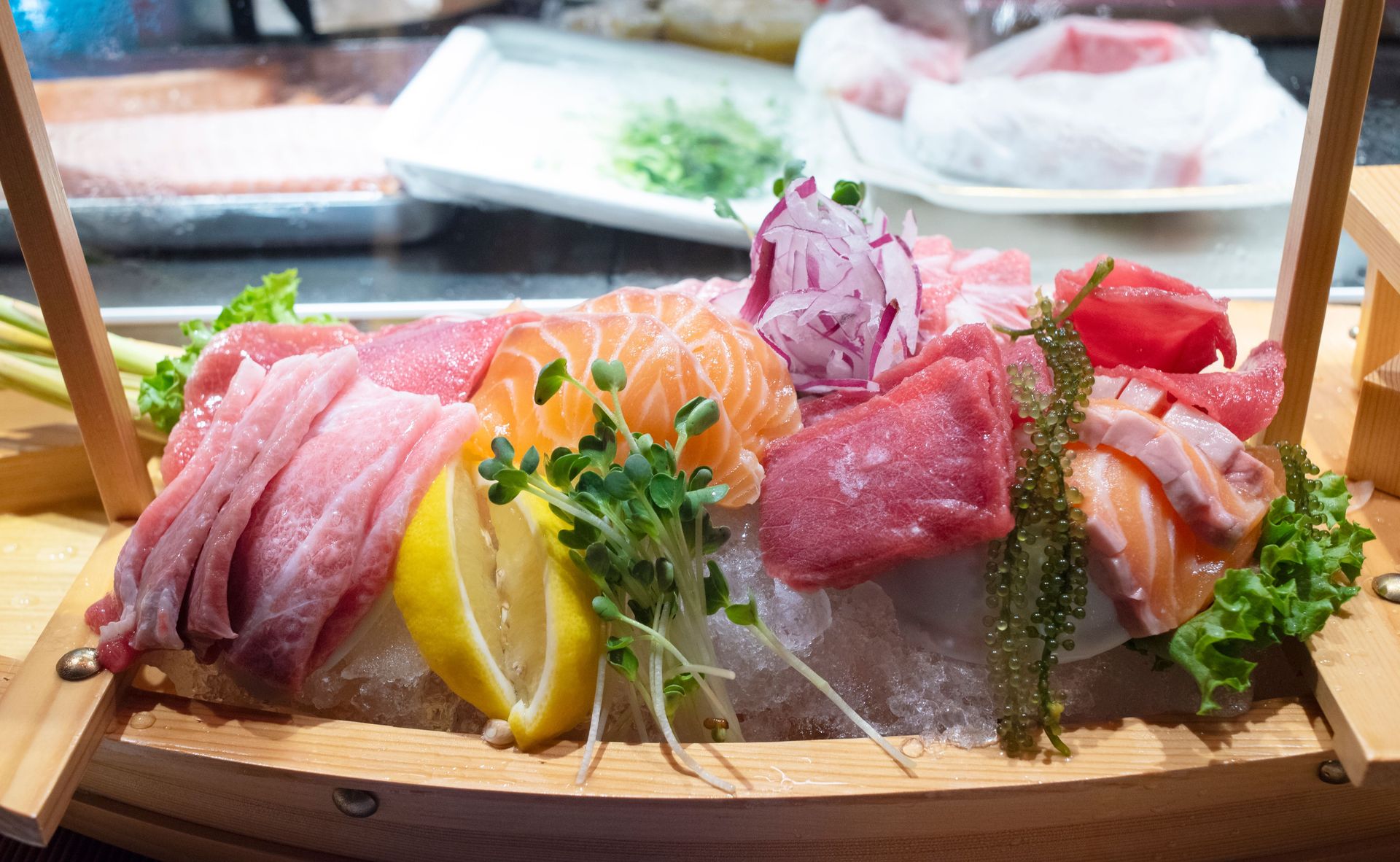 A vibrant sashimi set featuring fresh salmon, tuna, and lemons artfully presented on ice.